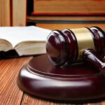 open-law-book-with-a-wooden-judges-gavel-on-table-in-a-courtroom-or-law-enforcement-office