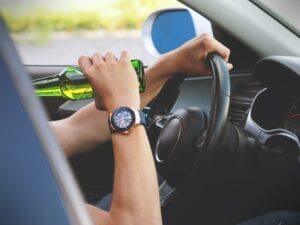 person drinking alcohol while driving